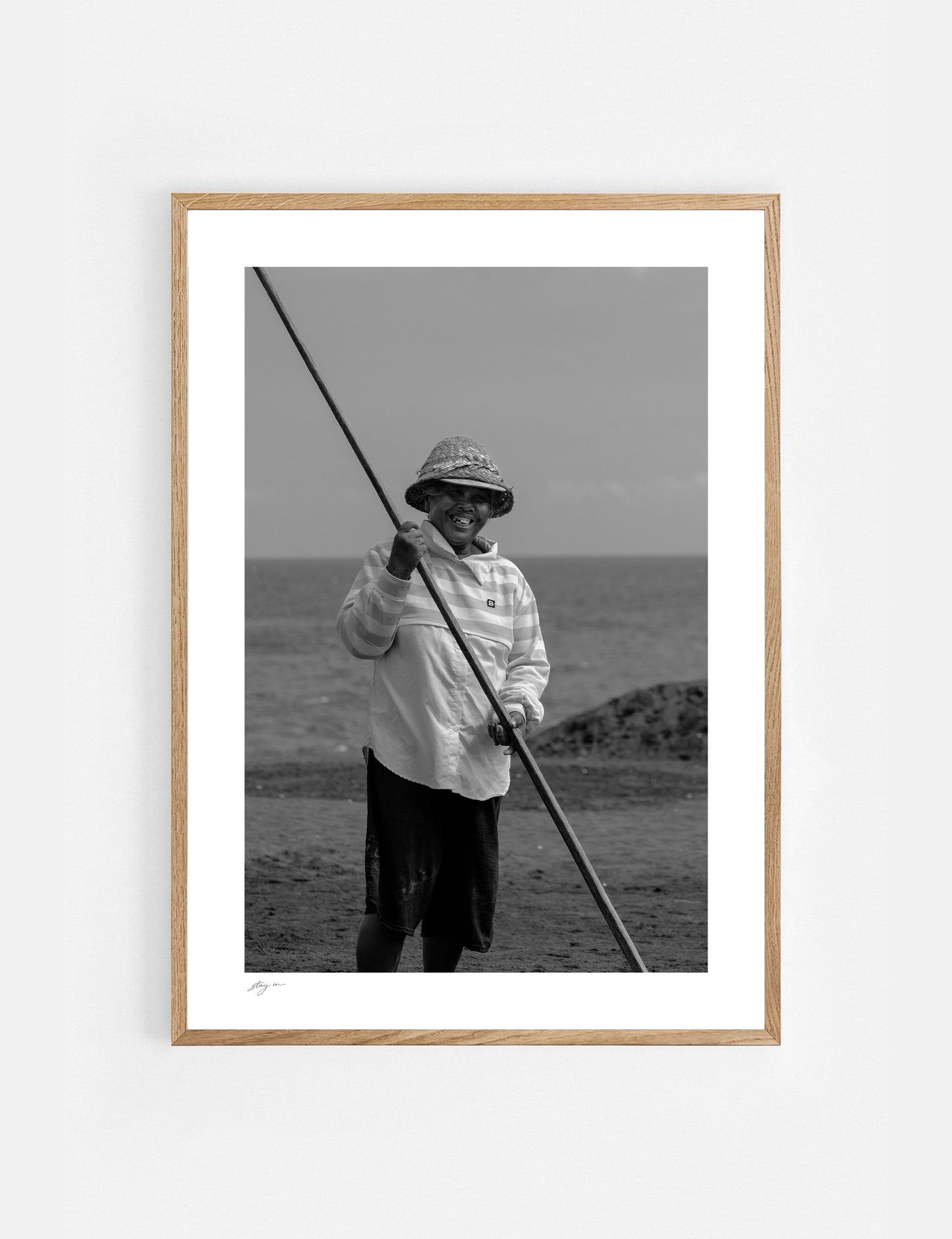 Black and white art print of a Balinese salt farmer harvesting sea salt by hand.