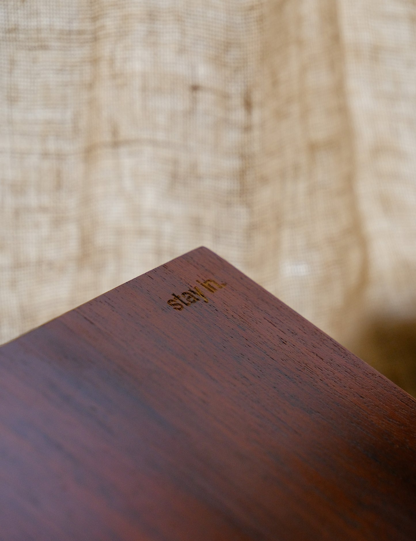 Wooden surface with 'stay in' branding on a blurred wooden background