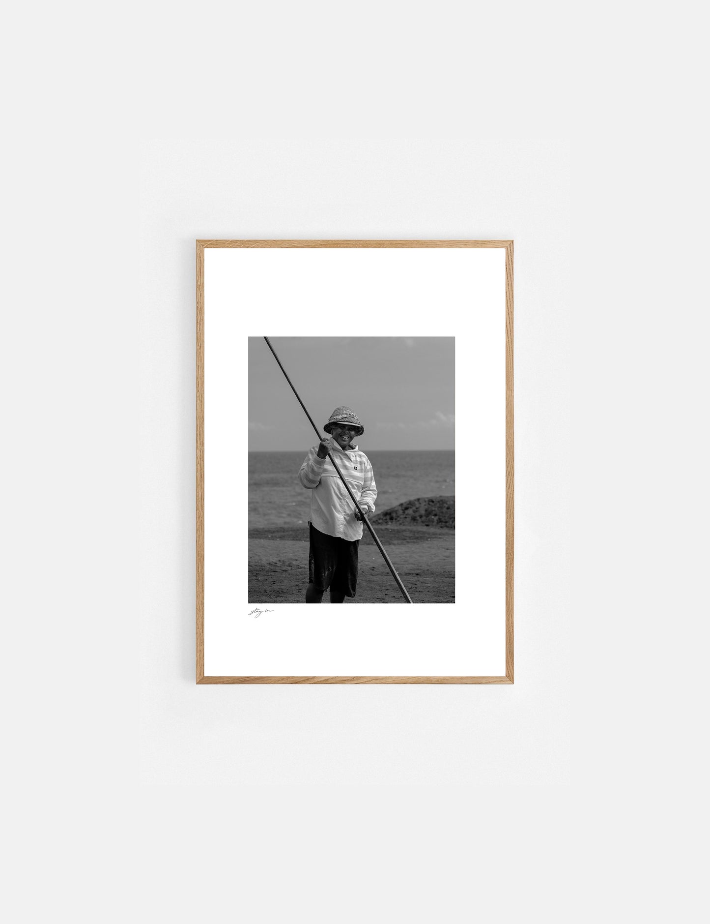 Black and white art print of a Balinese salt farmer harvesting sea salt by hand.