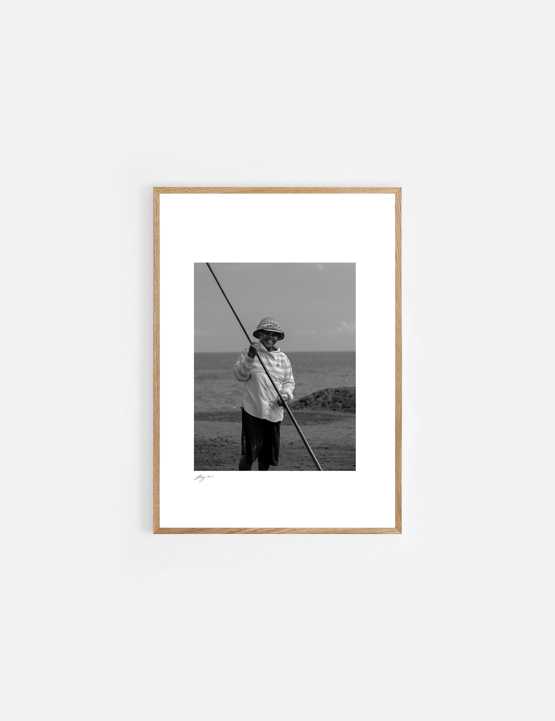 Black and white art print of a Balinese salt farmer harvesting sea salt by hand.
