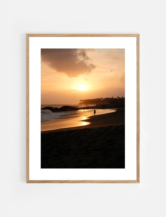 Framed photograph of a sunset over a beach with a wooden frame.